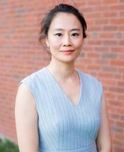 Dr. Alice Cheng smiling with her straight dark hair pulled back wearing a light blue sleeveless v-neck top