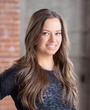 headshot photo of Chrissy Semler smiling with long brown hair and wearing a black top