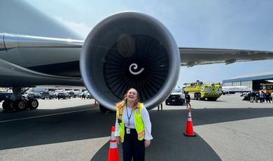 Sophia Schiappa stands in front of a large jet engine.