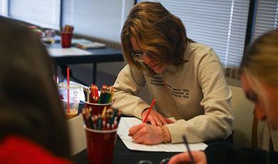 A student uses colored pencils to draw a mind map during a Life Design workshop.